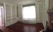 a room with a window and built-in bookshelves