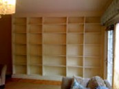 a room with a window and built-in bookshelves